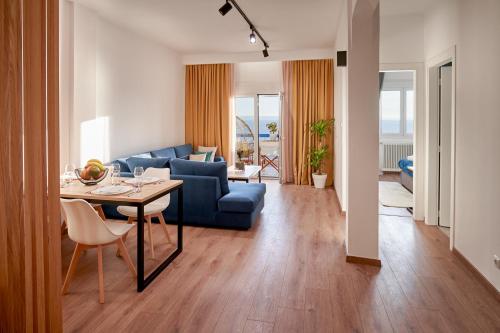 塞萨洛尼基Seafront Luxury President Suite Aegean Sunset的客厅配有蓝色的沙发和桌子