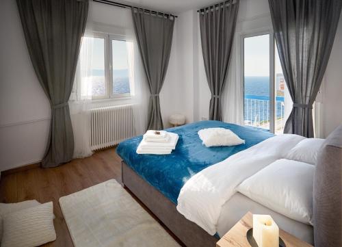 塞萨洛尼基Seafront Luxury President Suite Aegean Sunset的一间卧室设有一张大床和一个大窗户