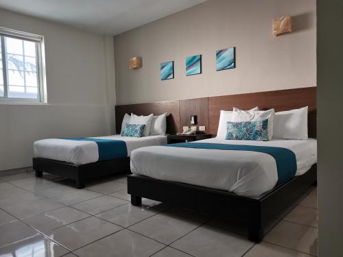 OcotlánHotel Pabela的酒店客房设有两张床和窗户。
