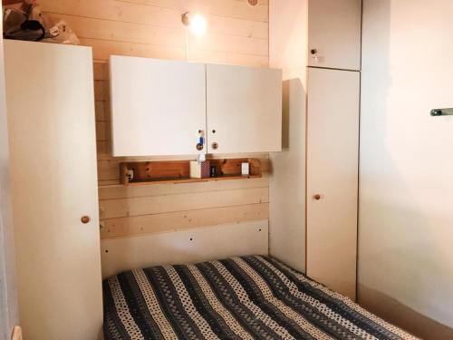加桑Chalet à Gassin au calme sous les pins的小房间设有一张床和白色橱柜
