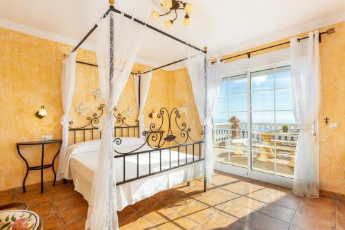 托罗克斯Villa Olympo的一间卧室设有一张天蓬床和一个阳台