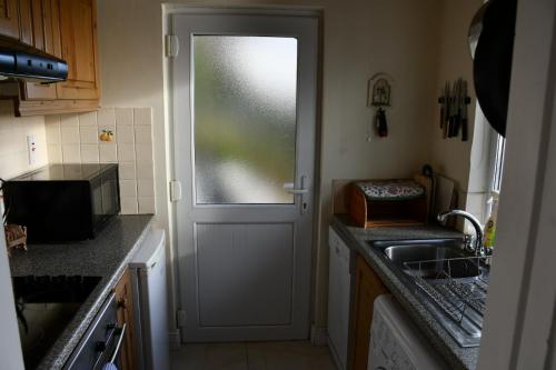 金塞尔Rocklands Cottage的厨房设有门、窗户和水槽