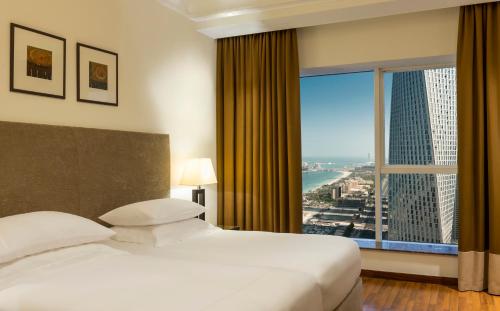 迪拜Grosvenor House, a Luxury Collection Hotel, Dubai的酒店客房设有一张床和一个大窗户