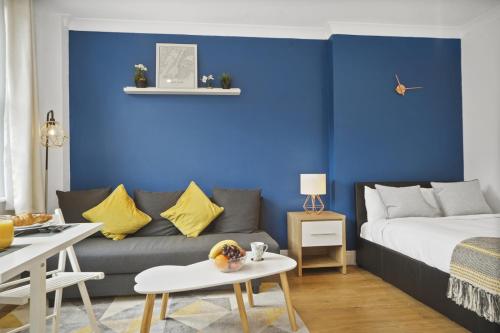 伦敦Studio Apartment by Homely Stays的带沙发和蓝色墙壁的客厅