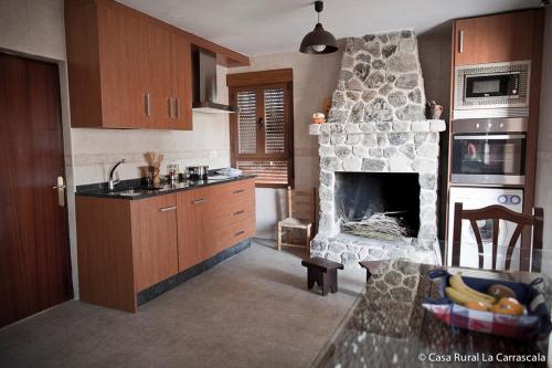 萨莫拉Casa Rural La Carrascala的一间厨房,在房间内配有石制壁炉