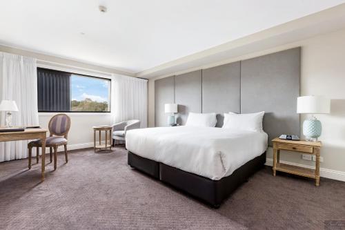 Terrey Hills米拉马尔花园精品住宿旅馆的酒店客房设有一张大床和一张书桌。