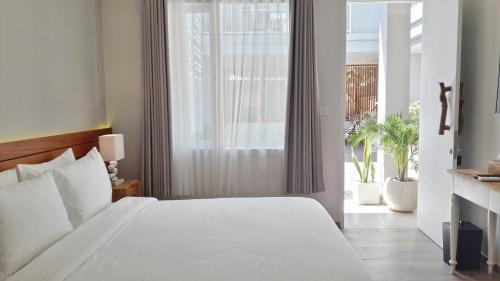 吉利特拉旺安Mantra Gili的卧室设有白色的床和大窗户