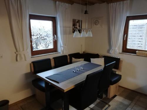 阿布特瑙Gaestehaus-Russegger的一间带桌子和黑色椅子的用餐室