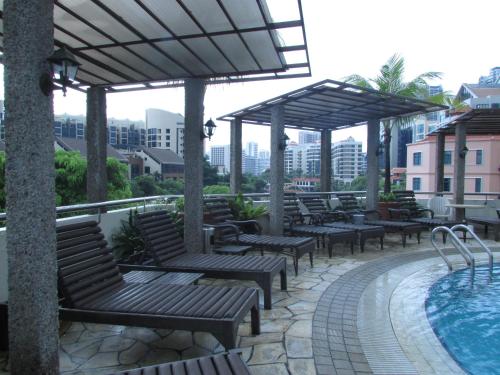 新加坡Robertson Quay Hotel的酒店庭院设有长椅和游泳池