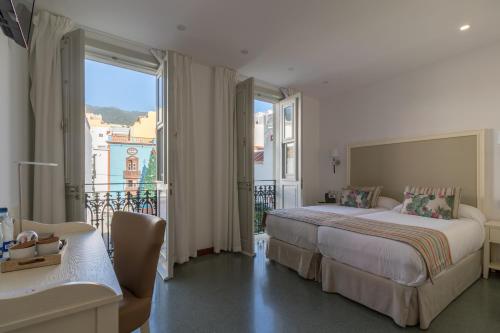 圣克鲁斯-德拉帕尔马Hotel Emblemático Holiday Time的酒店客房设有一张床和一个阳台。