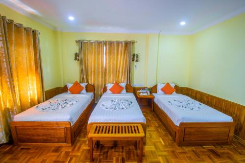 娘瑞Mother's Home Hotel的客房 - 带两张带橙色枕头的床