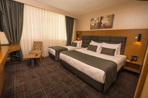 迪亚巴克尔New Garden Hotel的酒店客房配有两张床和一张书桌
