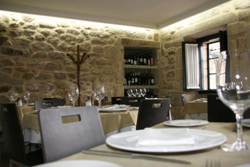 庞特维德拉鲁阿斯酒店及餐厅的用餐室配有桌椅和酒杯