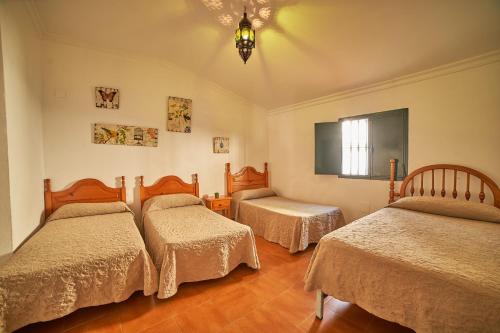 丰特埃里多斯VILLA IRENE的一间卧室设有三张床和窗户。
