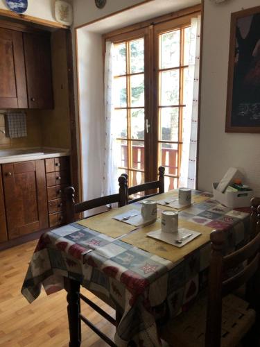 萨奥兹-杜尔克斯APPARTAMENTO MONTAGNA SAUZE D OULX的厨房配有桌子和桌布