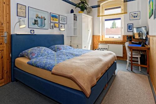 希尔德斯海姆Moltkestrasse 89的一间卧室配有蓝色的床和一张书桌