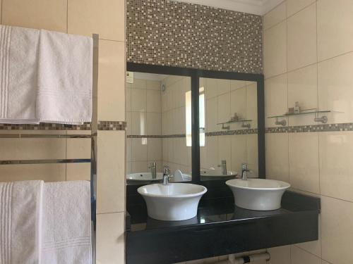波罗瓜尼Royal Hotel的一间带两个盥洗盆和大镜子的浴室