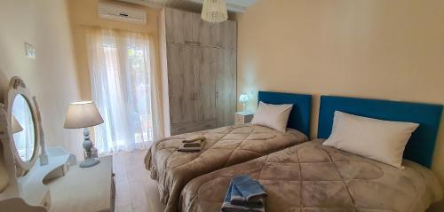 阿查拉维La casa di Eleni的一间卧室设有两张床、一盏灯和一扇窗户。