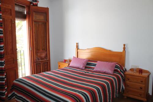 卡皮雷拉Apartamento Rurales Rosendo: Poleo Menta的一间卧室配有一张带条纹毯子的床和窗户