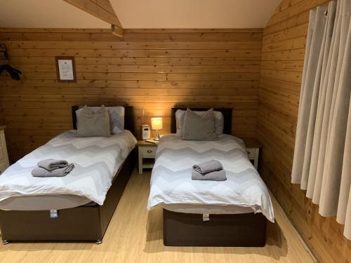 迪德科特Southernwood - Garden Lodge 2的木墙客房的两张床