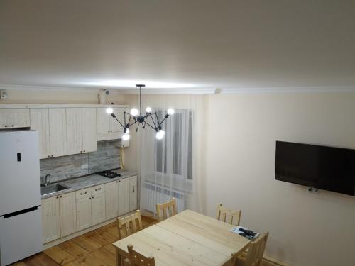 迪利然Petit Dilijan的厨房配有桌子和白色冰箱。