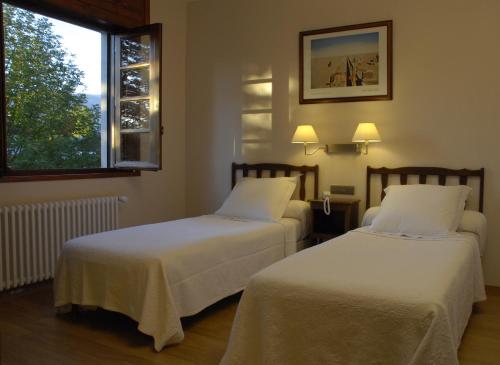 布尔马当萨利苏尔酒店的配有窗户的酒店客房内的两张床