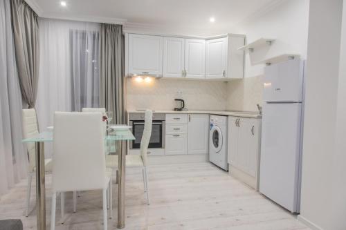 布尔加斯Vip Luxury APARTMENT的厨房配有白色家电和桌椅