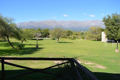 拉斯罗萨斯Cabañas Tintihuasi的一个带栅栏的场地和一个有山的足球场