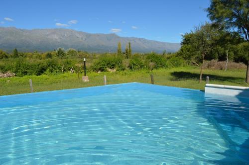 拉斯罗萨斯Cabañas Tintihuasi的一座蓝色的游泳池,后面是群山