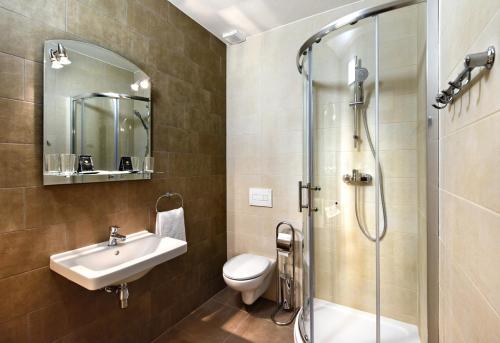 卢切内茨Hotel Pelikán的浴室配有盥洗盆、卫生间和淋浴。