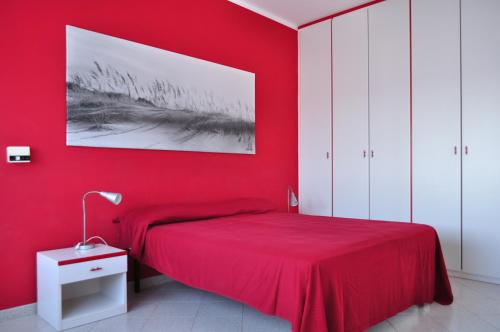 莫尔恰诺迪莱乌卡Casa BelMar的红色的卧室,配有一张床和红色的墙壁