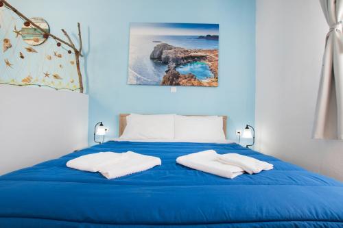 卡尔帕索斯Captain Elias Studios 2的一张蓝色的床,上面有两条白色的毛巾