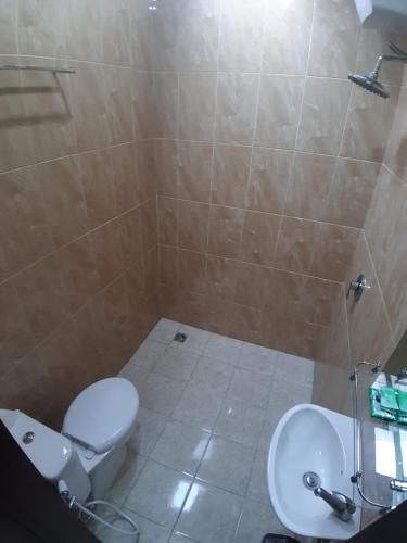 PesanggaranD&D homestay的浴室配有卫生间、盥洗盆和淋浴。