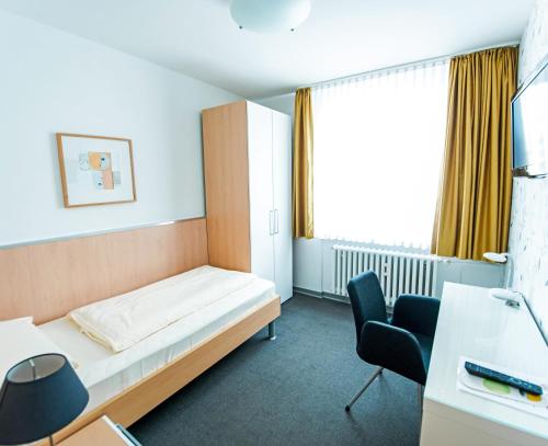基尔弗拉米斯彻酒店的酒店客房,配有一张床、一张桌子和椅子
