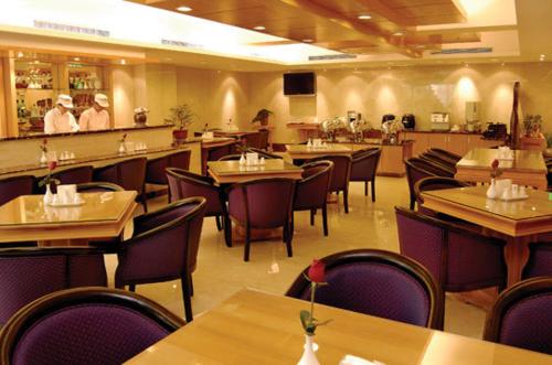 中坜凯都大饭店的餐厅设有桌椅,背景人员