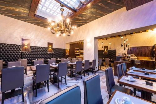 威尼斯阿巴泽亚酒店的一间带桌椅和吊灯的用餐室