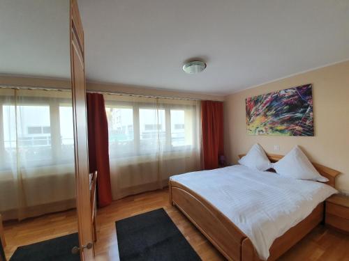 锡永梅尔查特莱兰酒店的卧室配有一张床,墙上挂有绘画作品