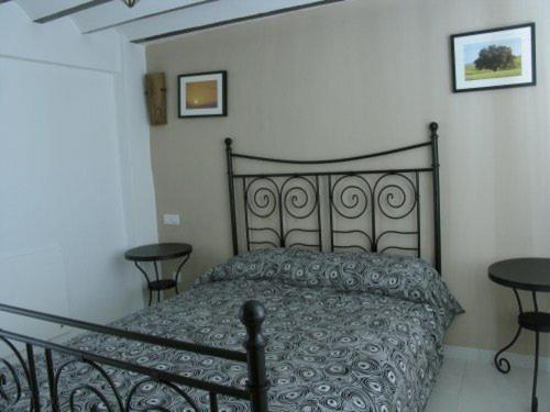 韦斯卡尔Casa El Minarete的一间卧室配有一张带两张桌子的黑色床