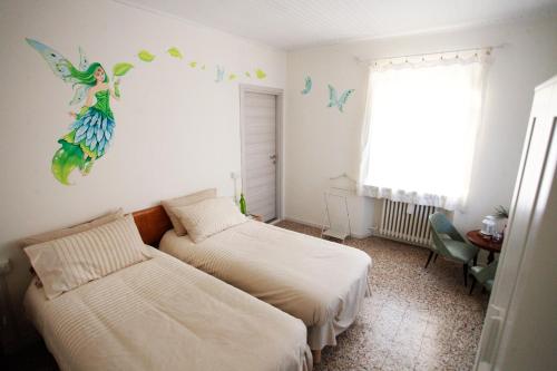 GessoCasa Cristallo的卧室配有两张床,墙上挂着美人鱼壁画