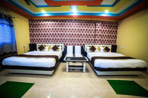 西里古里Tirupati Lodge NJP的一间客房内配有两张床的房间