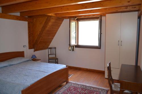 圣安蒂奥科Casa Vacanze Cala Sapone的一间卧室设有一张床、一个窗口和一张桌子