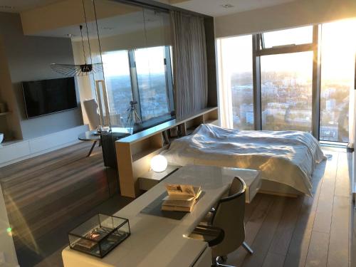 弗罗茨瓦夫Vantage Point Apartament Sky Tower的配有一张床、一张桌子和一张桌子的酒店客房