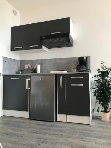 勒阿弗尔Studio Meublé Vue Mer的厨房配有黑色冰箱和炉灶。