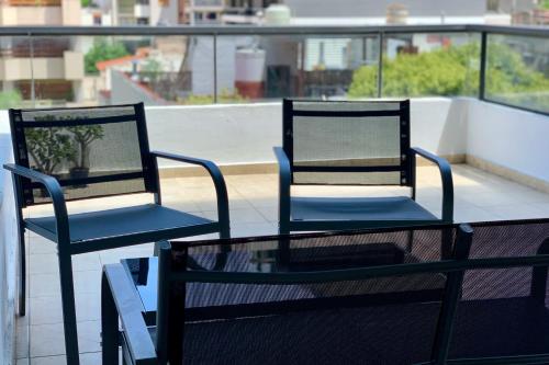 科尔多瓦Ayres de Córdoba, Gran Terraza, Excelente Ubicación的阳台上配有两把椅子和一张玻璃桌