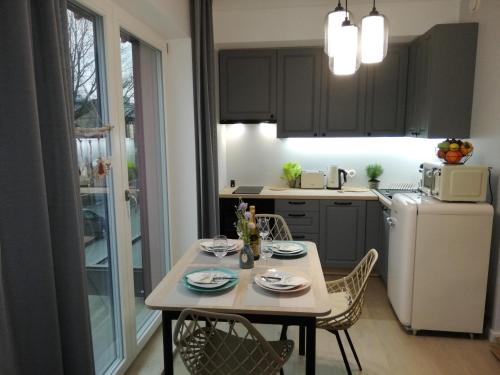塔林VP Kalamaja Apartment with garage的厨房配有桌椅和白色冰箱。