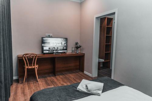 阿克托比ЖОМАРТ的一间卧室配有一张桌子、一台电视和一把椅子
