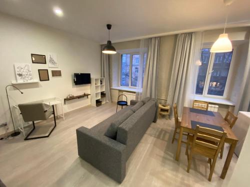 莫斯科Aparthotel Lind的客厅配有灰色的沙发和桌子