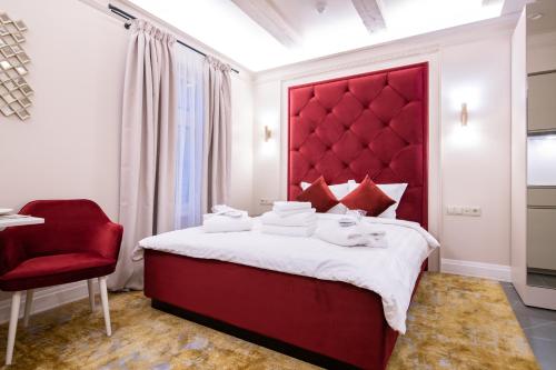 塔林Hotel Meltzer Apartments的一间卧室配有红色床头板和红色椅子