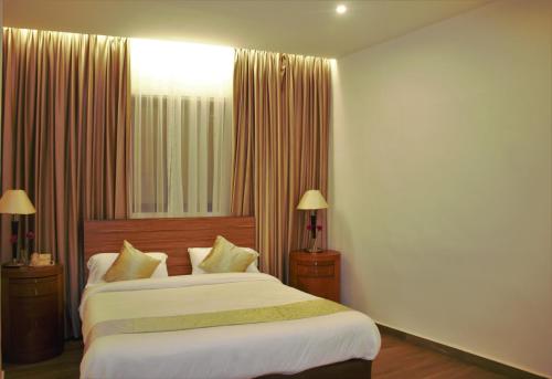 安曼New MerryLand Hotel的一间卧室配有一张带白色床单的大床