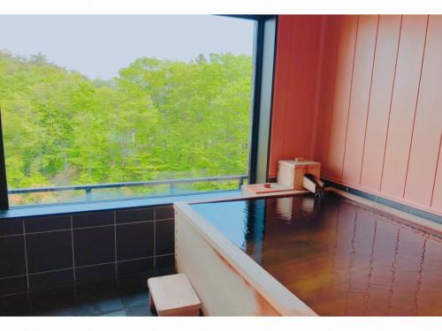 一关Kajitsu no Mori的客房设有浴缸和大窗户。